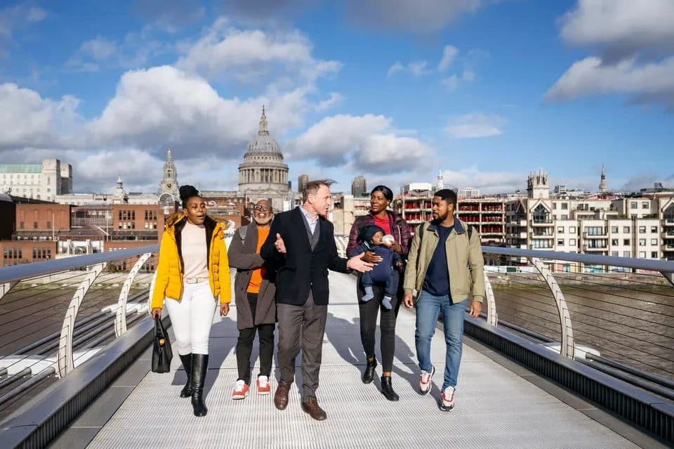 A walking tour group crossing a bridge in London with their guide